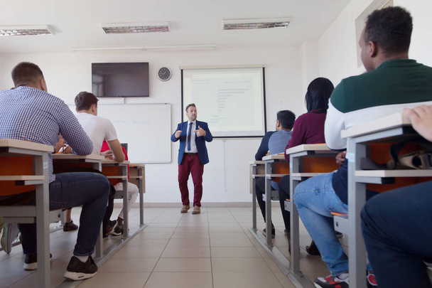 Professor do sexo masculino explicar lição para os alunos e interagir com eles - Foto, Imagem