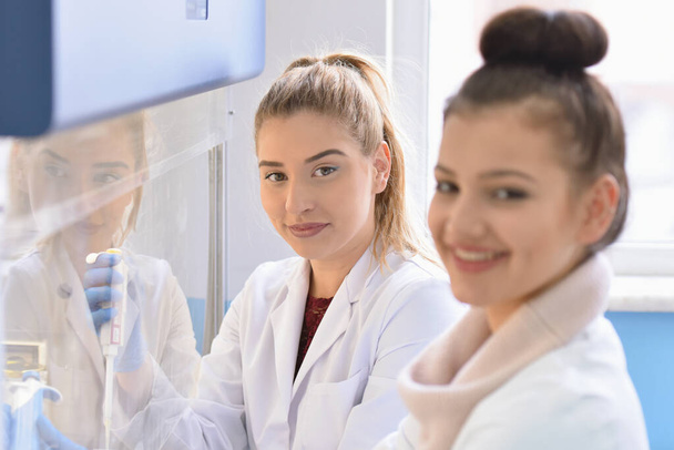 Δύο νεαρές γυναίκες εργαστηριακός επιστήμονας που εργάζονται στο εργαστήριο με test t - Φωτογραφία, εικόνα