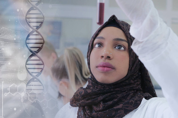 Jeune scientifique africaine musulmane travaillant en laboratoire avec test t - Photo, image