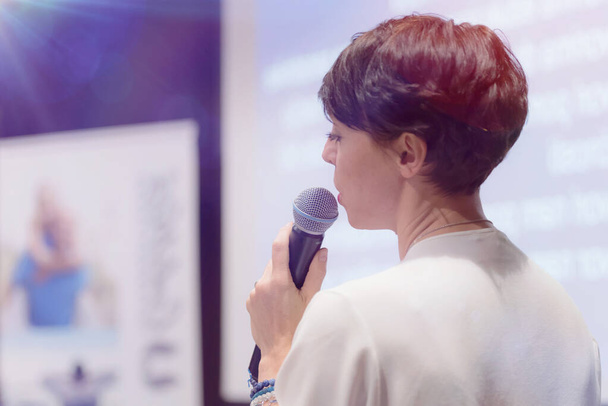 Beautiful business woman with microphone in her hand speaking at - Photo, Image