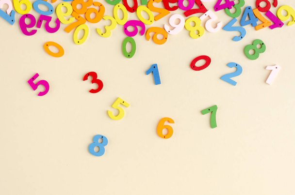 Colored wooden numbers composition on beige background. - Foto, imagen