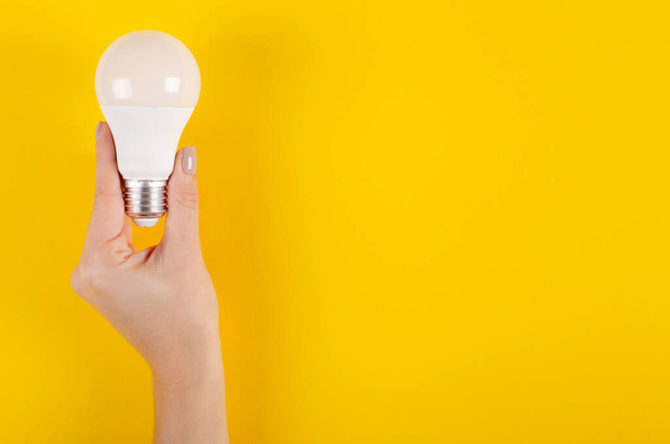 LED light bulb composition on yellow background. - Foto, Imagen