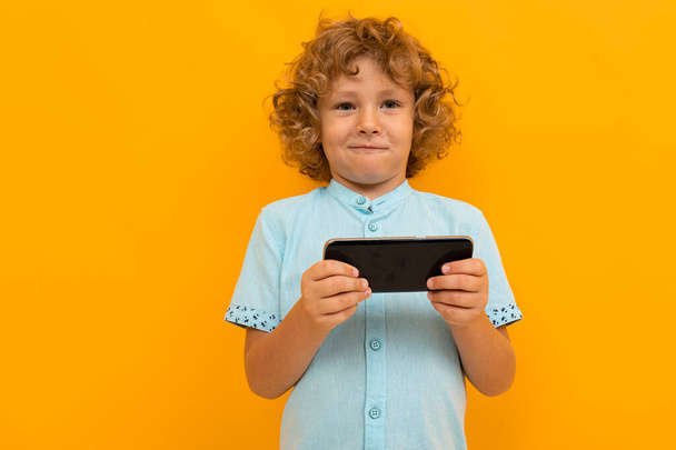 little boy posing against orange background  - Photo, Image