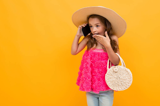 little girl like lady posing with mobile phone against orange background  - Foto, immagini