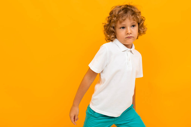 little boy posing against orange background  - Foto, imagen