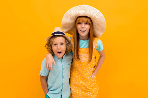 roztomilý chlapec a dívka pózovat proti oranžové pozadí  - Fotografie, Obrázek