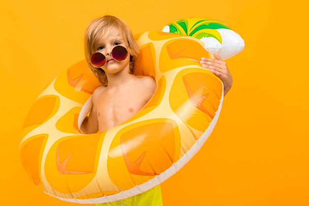cute boy with rubber ring against orange  - Fotó, kép