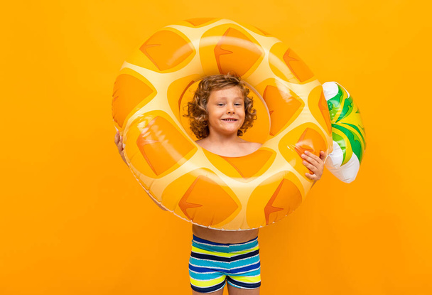 mignon petit garçon avec anneau en caoutchouc sur fond orange
  - Photo, image