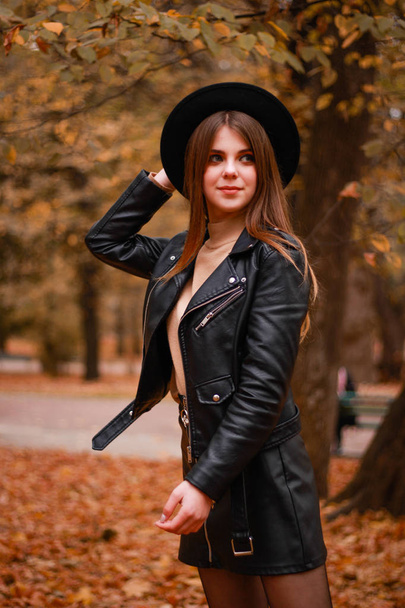 Stylish autumn girl in the park. Sweater, hat and leather jacket - Fotografie, Obrázek