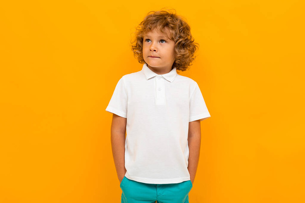 Küçük çocuk turuncu arka planda poz veriyor  - Fotoğraf, Görsel