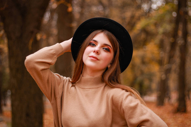 Autumn girl in the park. Sweater, hat and leather skirt. Stylish - Foto, imagen