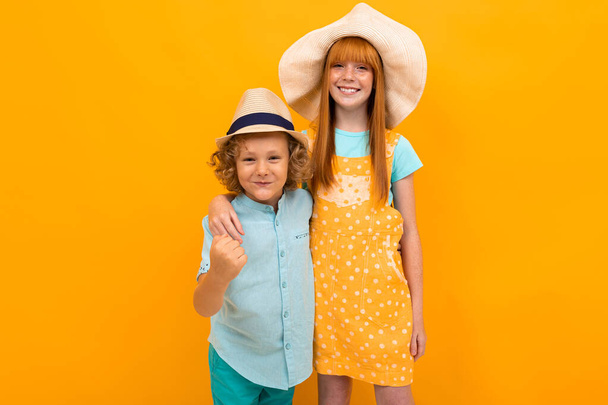 süße Jungen und Mädchen posieren vor orangefarbenem Hintergrund  - Foto, Bild