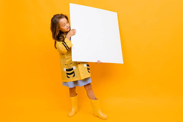 little girl with white board against orange background  - Фото, зображення