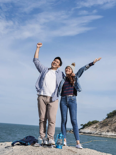 Happy Asian couple raising hands together with nature background - Φωτογραφία, εικόνα