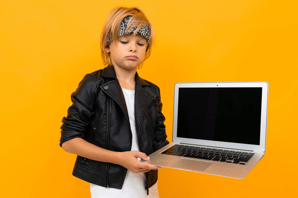 boy with laptop posing against orange  - 写真・画像