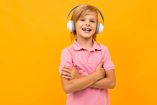 χαριτωμένο μικρό αγόρι με ακουστικά κατά πορτοκαλί  - Φωτογραφία, εικόνα