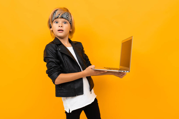 хлопчик з ноутбуком позує проти апельсина
  - Фото, зображення
