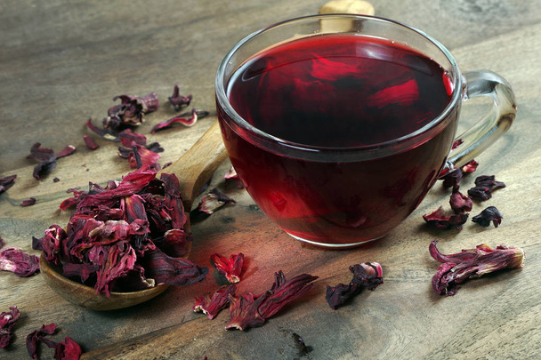 Hibiscus-teetä. Hibiscus puulusikassa ja kuppi tuoretta teetä. Vitamiini teetä kylmä ja flunssa
. - Valokuva, kuva