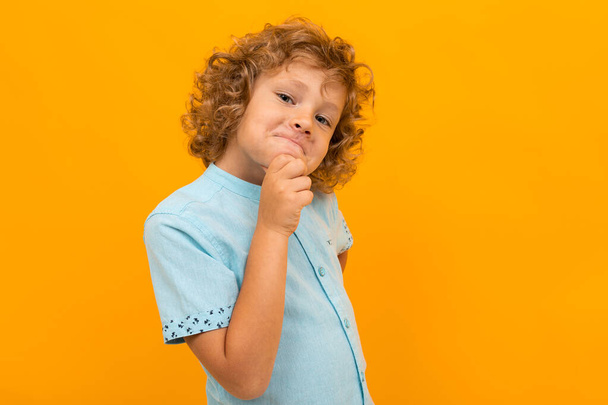 little boy posing against orange background  - Фото, изображение