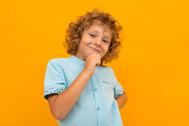 маленький хлопчик позує на помаранчевому фоні
  - Фото, зображення