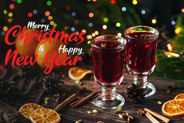 zimowy gorący napój grzane wino w szklankach na stole z napisem Wesołych Świąt i Szczęśliwego Nowego Roku - Zdjęcie, obraz