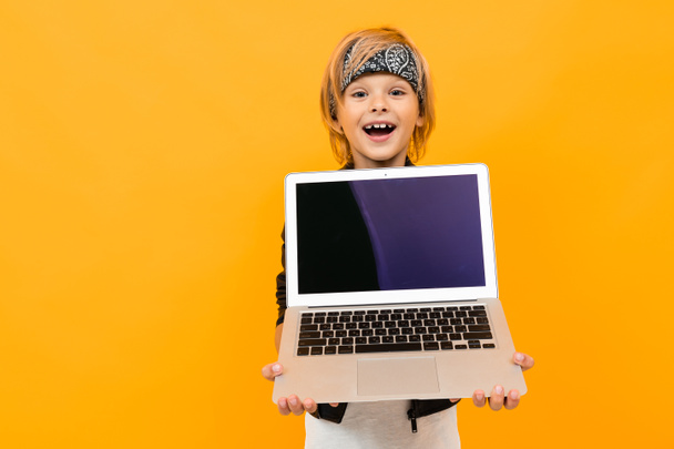 boy with laptop posing against orange  - Foto, Imagen