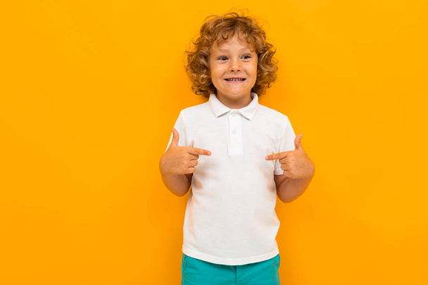 маленький мальчик позирует на оранжевом фоне
  - Фото, изображение