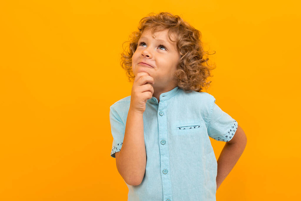 kleiner Junge posiert vor orangefarbenem Hintergrund  - Foto, Bild