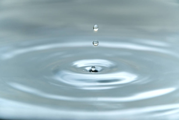 水面に衝突する前に空気中に浮く水の滴は、美しいスプラッシュ、クローズアップ写真を引き起こします - 写真・画像