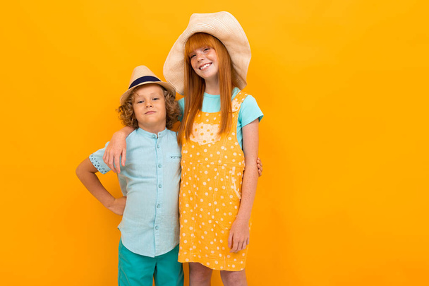 aranyos fiú és lány pózol ellen narancs háttér  - Fotó, kép