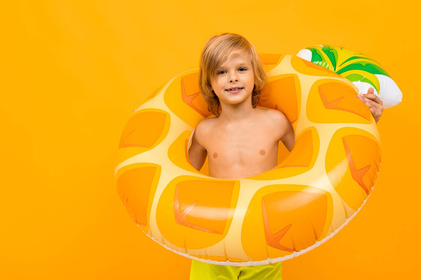 carino bambino con anello di gomma posa contro sfondo arancione
  - Foto, immagini