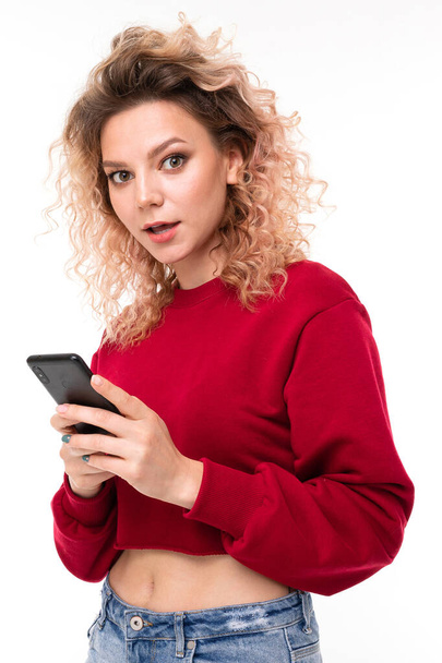 young woman posing with mobile phone against white background   - Fotó, kép