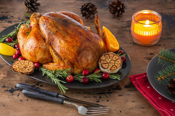 Christmas chicken with thyme and cranberries on a wooden table. Christmas atmosphere. - Photo, image