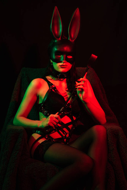 sexy dominatriz mujer en lencería erótica con máscara de conejo con látigo de cuero
 - Foto, imagen