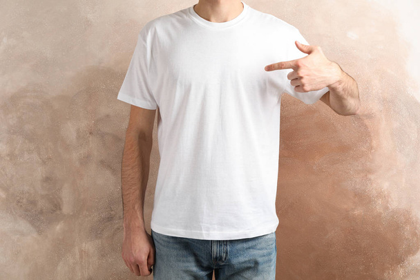 Men in blank white t-shirt against brown background, space for t - Fotoğraf, Görsel