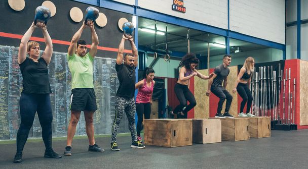 Athletes exercising with kettlebells and doing box jumps - Photo, Image