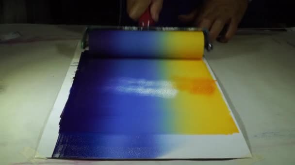 Put yellow on the blue tone. Drop the yellow color on the white side and use a roller to scrub back and forth. - Footage, Video