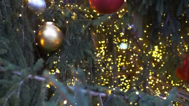 Geceleri parlayan bir Noel ağacı ışığını kapat. Süslemeleri ve aydınlatması olan yeni yıl ağacı. Xmas ağaç dekorasyonu arkaplanı. - Video, Çekim