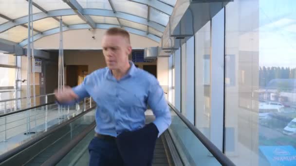 Successful businessman walking through hall of terminal and dancing. Happy handsome man celebrating his achievement or success. Cheerful guy enjoying win and dancing victory dance. Slow mo Front view - Footage, Video