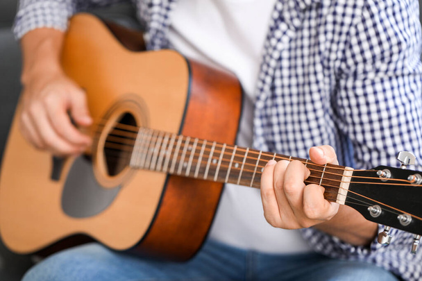 Человек, играющий на гитаре дома, крупным планом
 - Фото, изображение