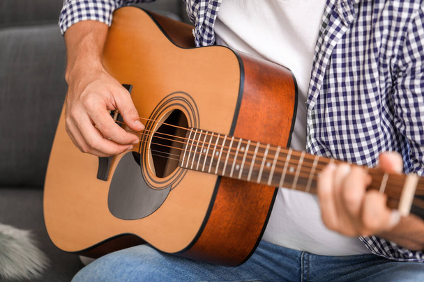 Άντρας που παίζει κιθάρα στο σπίτι, κοντινό πλάνο - Φωτογραφία, εικόνα
