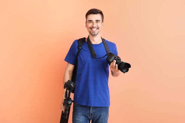 Jonge mannelijke fotograaf op kleur achtergrond - Foto, afbeelding