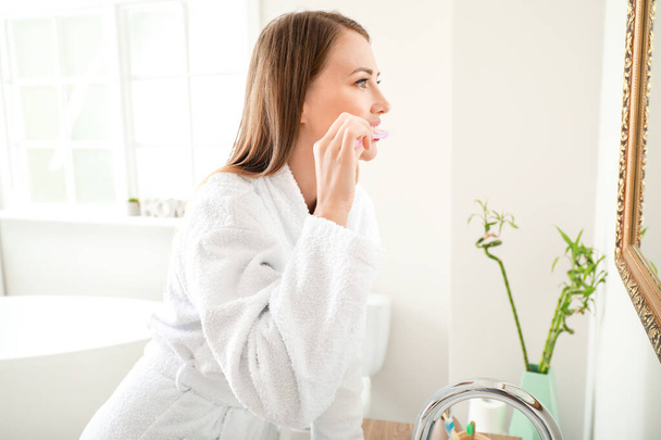 Banyoda dişlerini fırçalayan kadın. - Fotoğraf, Görsel