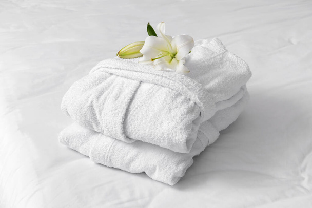 Soft clean bathrobes on bed - Foto, imagen