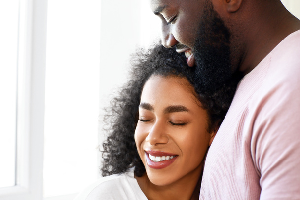 Портрет счастливой афро-американской пары у окна
 - Фото, изображение