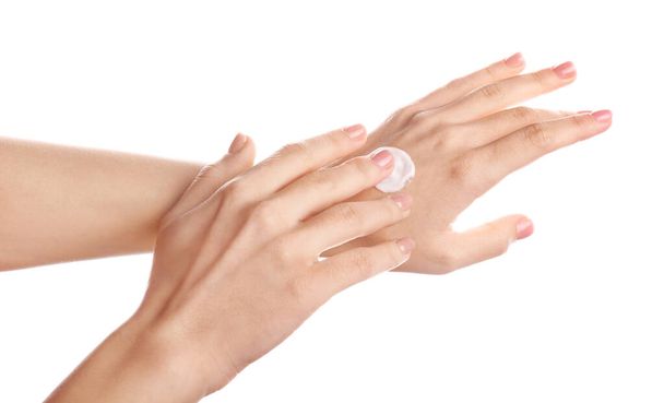 Young woman applying hand cream against white background - Photo, Image