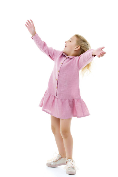 A little girl in a dress is spinning. - Фото, зображення