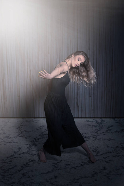 Beautiful dancer - young woman dance over dark gray background - Valokuva, kuva