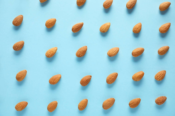 Many tasty almonds on color background - Fotoğraf, Görsel