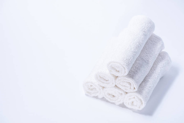 Serviettes en éponge roulées doucement pour spa ou massage sur un fond blanc
 - Photo, image